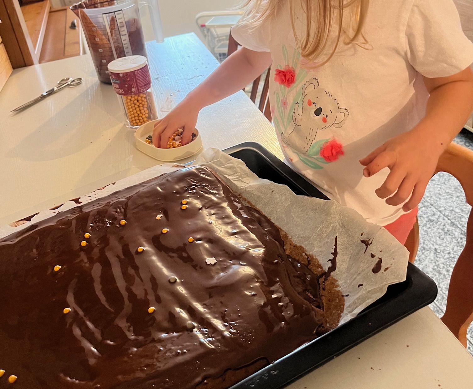 Kind verziert einen Schokoladenkuchen