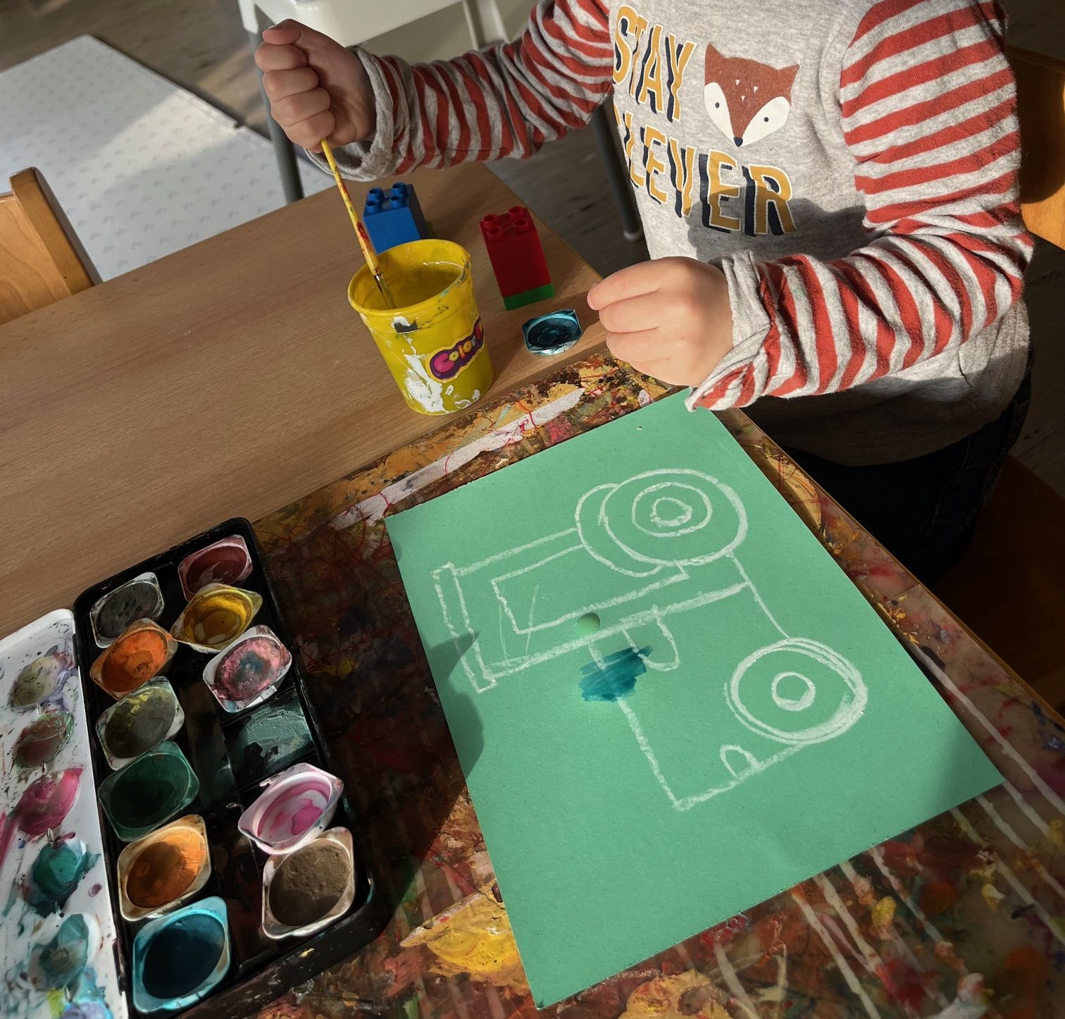 Kind malt mit Wasserfarben