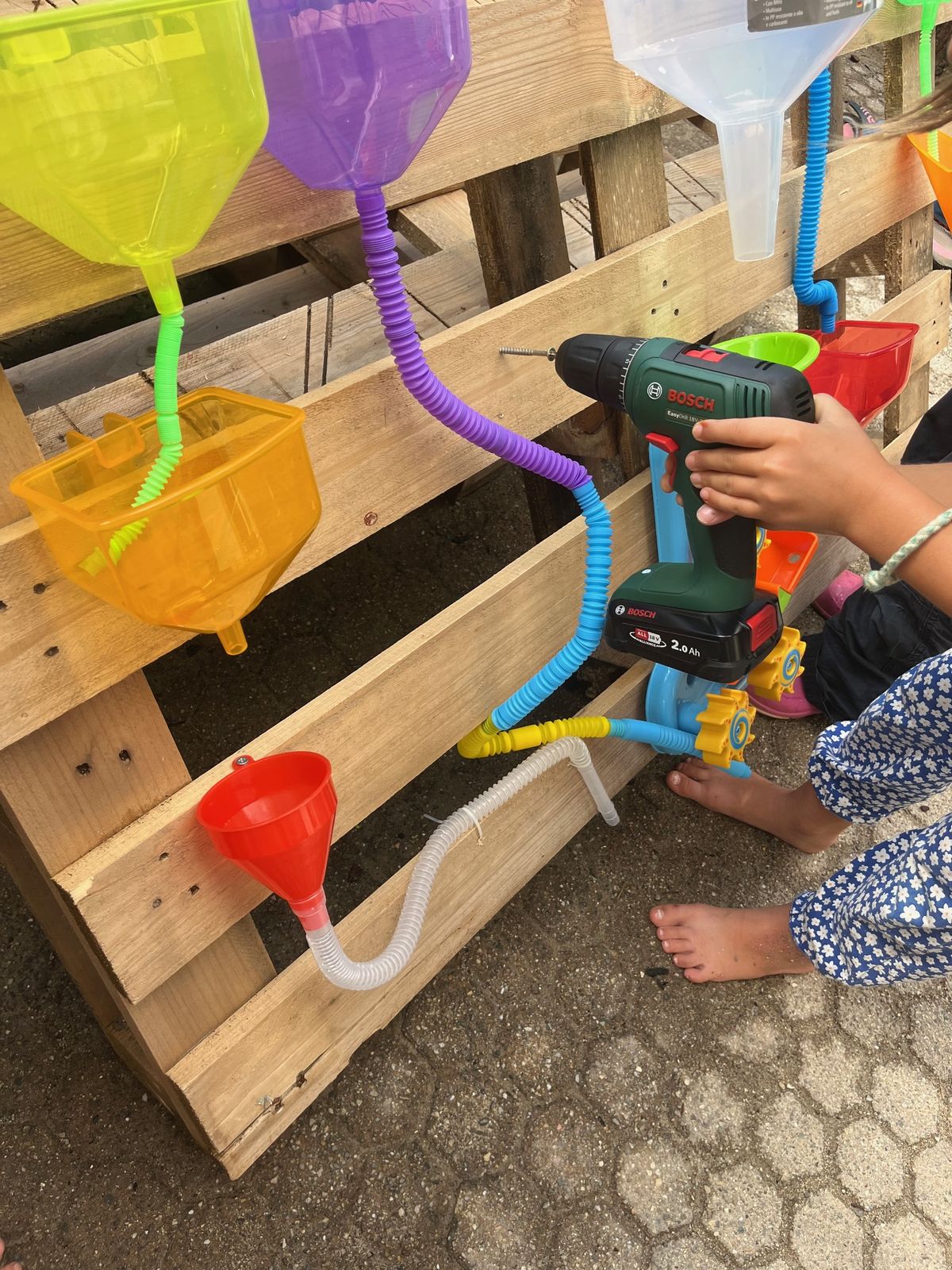 Kind arbeitet an der Wasserspielwand