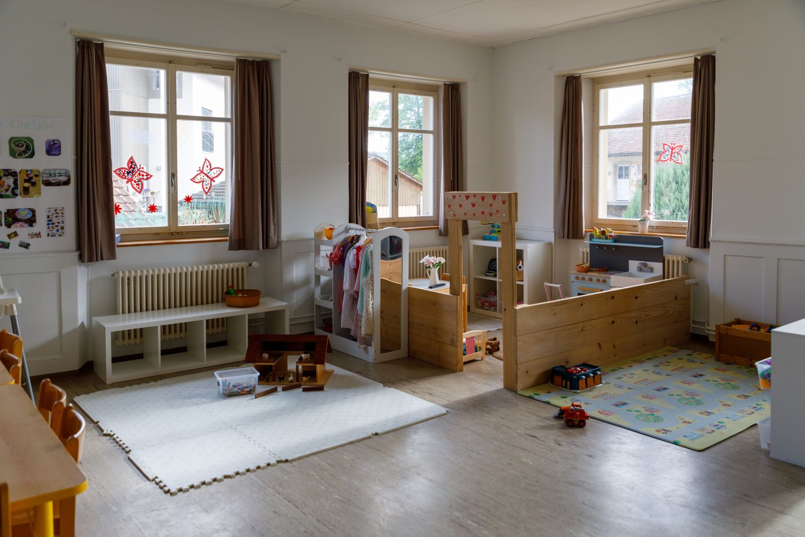Gruppenraum der Kita Wisebärg in Rünenberg mit Spielbereich und hohen Fenstern