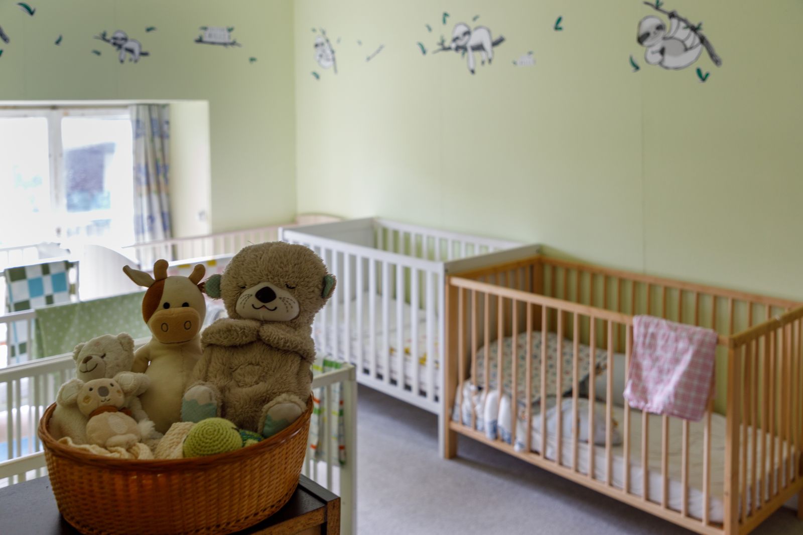 Schlafzimmer der Kita mit Babybetten und Kuscheltieren