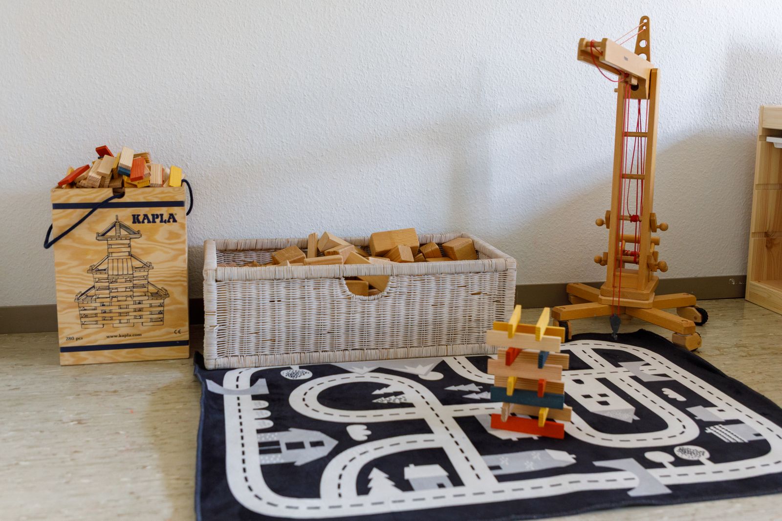 Spielteppich mit Strassenmotiv und Holzspielzeug